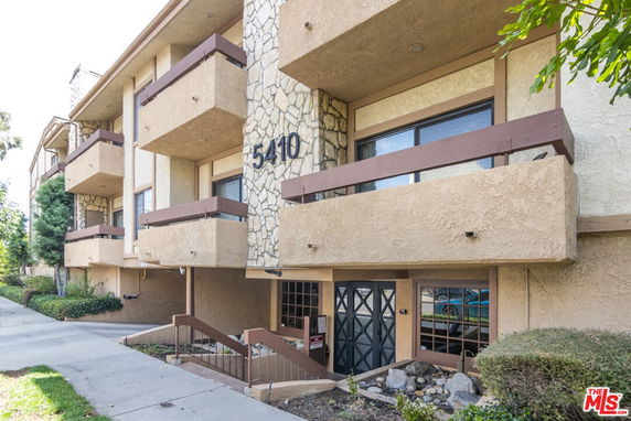 Front view of a multi-story building with balconies and stone accents.