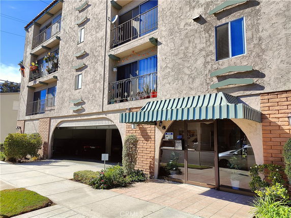 Front view of a multi-story apartment building with balconies.