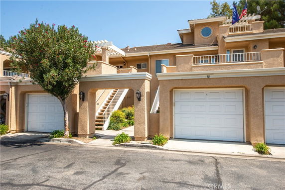 Front view of a two-story building with garages and balconies.