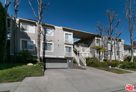 Front view of a multi-story apartment building with staircase and balconies.