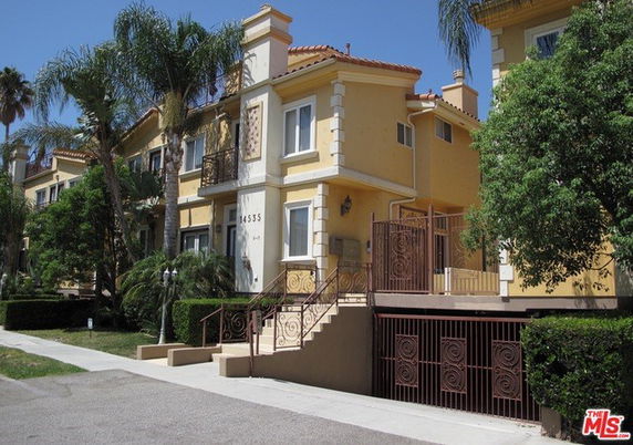 Front view of a two-story building with stairs leading to the entrance.