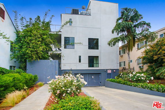 Front view of a multi-story building with a gated entrance.