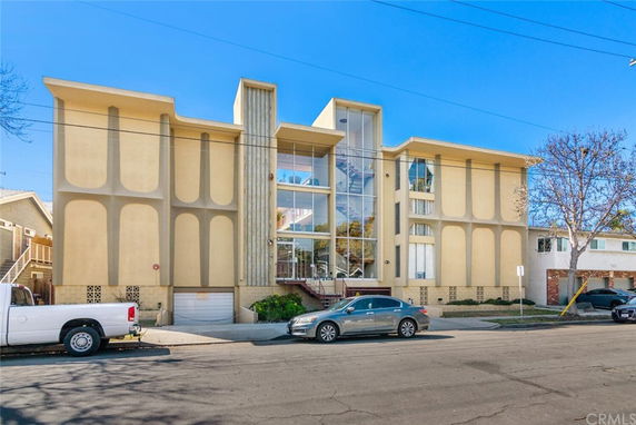 Front view of a multi-story building with large glass windows and decorative facade.