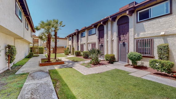 Front view of a two-story residential building with a garden pathway.