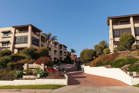 Front view of a multi-story residential building complex with gated entry.