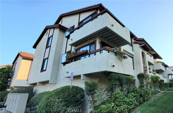 Front view of a multi-story residential building with balconies.