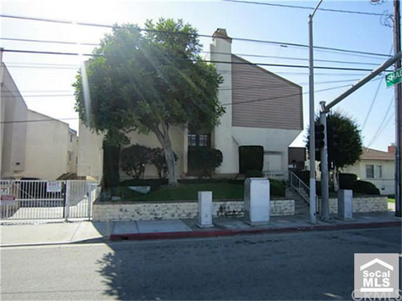 Front view of a multi-story building on a corner with a gated entrance.