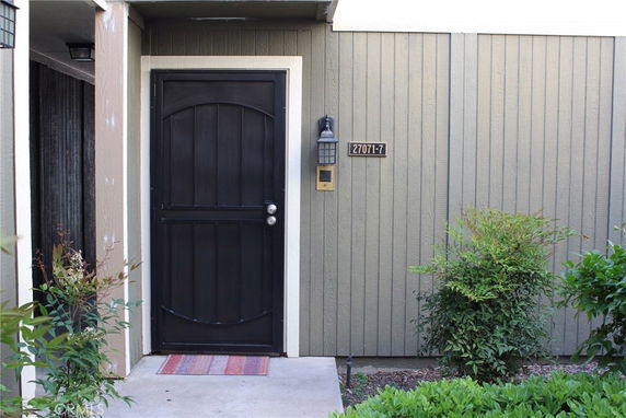 Front view of a house entrance with a black door and house number.