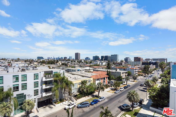 Wide-angle view of a cityscape with multiple buildings and a clear sky.