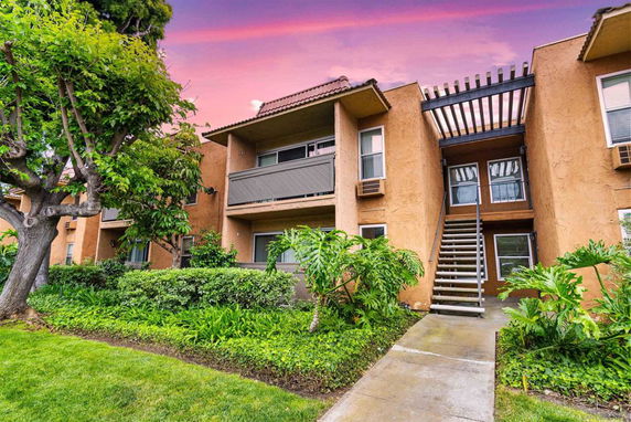 Front view of a two-story apartment building with external staircase.