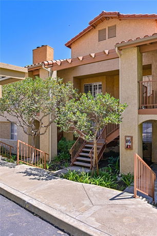 Front view of a multi-level house with a staircase leading to the entrance.
