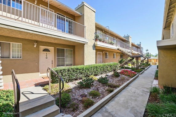 Front view of a multi-story apartment building with balconies.