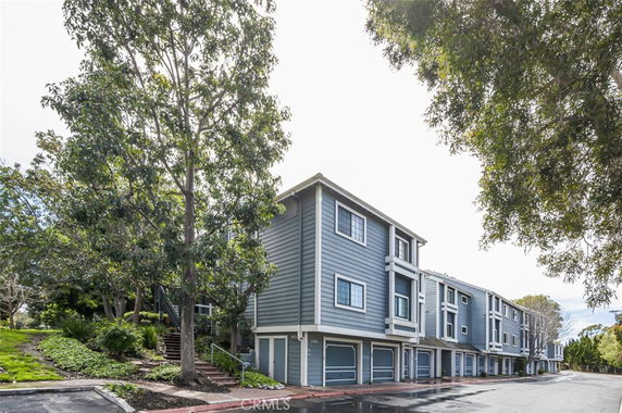 Front view of a multi-story residential building with a row of garages at the ground level.