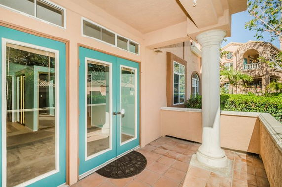 Front view of a house with blue-trimmed glass doors and a column.
