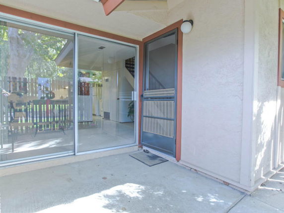 Front view of a house entrance with a sliding glass door and screen door.