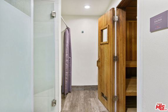 Interior view of a sauna room with wooden door and panels.