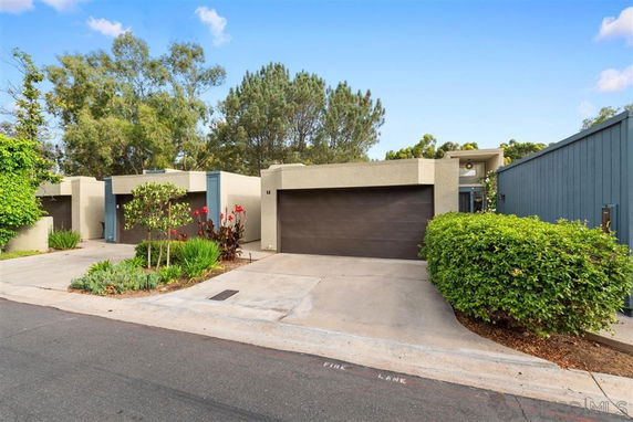 Front view of a modern single-story house with a garage and driveway.