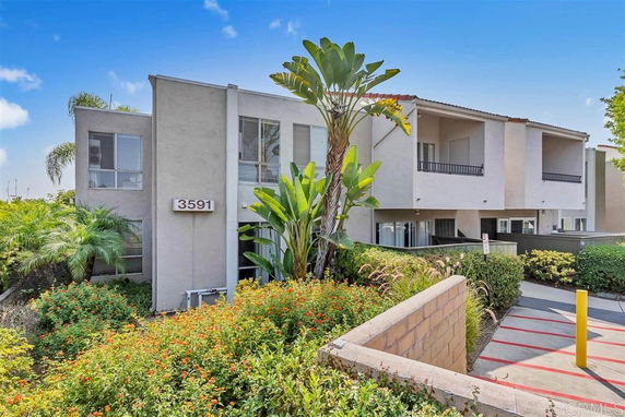 Front view of a modern multi-story apartment building with balconies.
