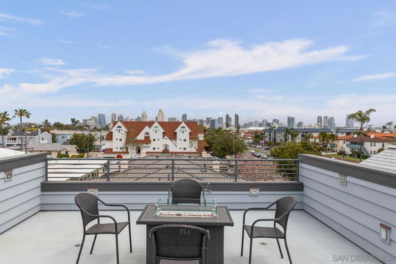 Rooftop terrace with seating and downtown skyline in the background.