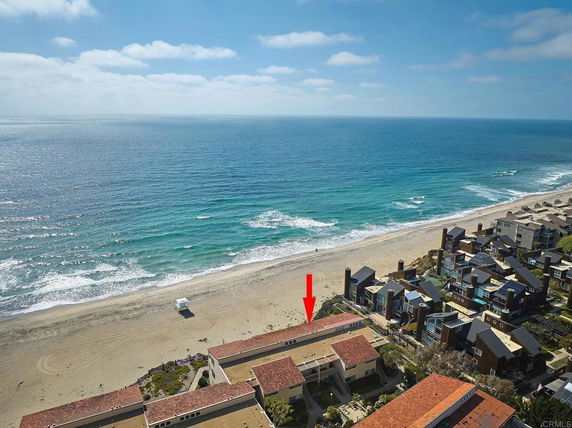 Panoramic view of buildings along a beachside with ocean in the background.