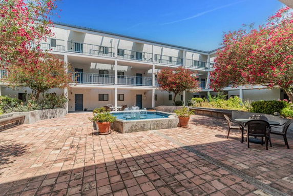Courtyard view of a multi-story building with a fountain in the center.