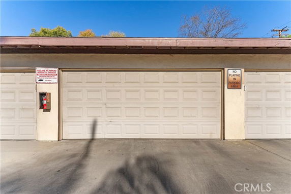 Outdoor parking area with closed garage doors.