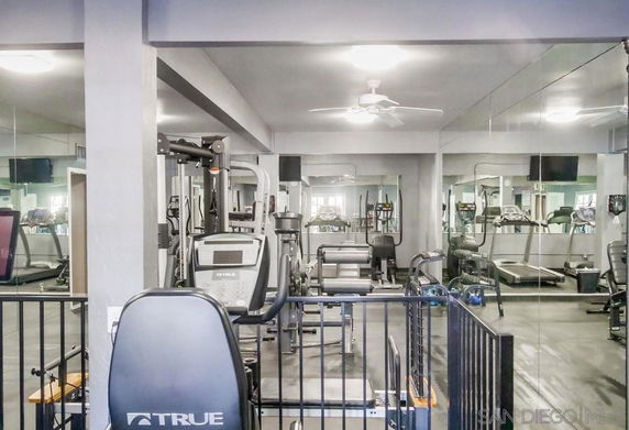 Interior view of a gym with exercise equipment and mirrored walls.