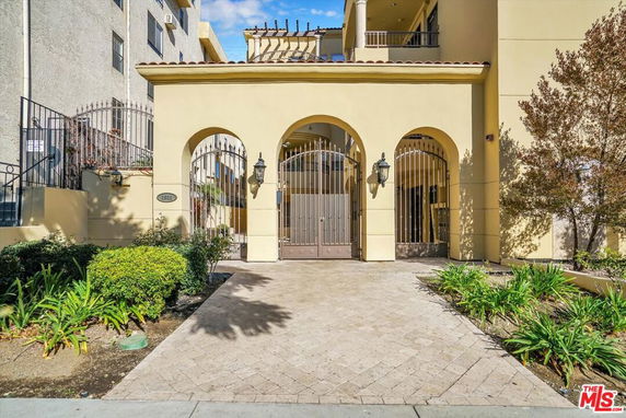 Front elevation of a building with arched gate entrances.