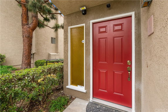 Entrance view of a building with a red door and glass panel