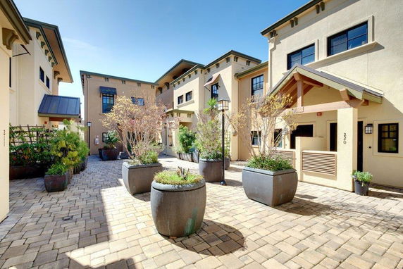 Front view of a townhouse complex with multiple units and decorative planters.