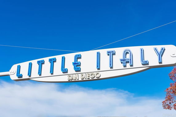 Sign reading 'Little Italy San Diego' against a blue sky.
