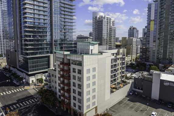 Elevated view of a modern multi-story building with glass and concrete architecture in an urban setting.