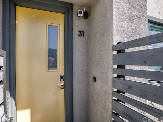 Front view of a house entrance with a yellow door and modern design.