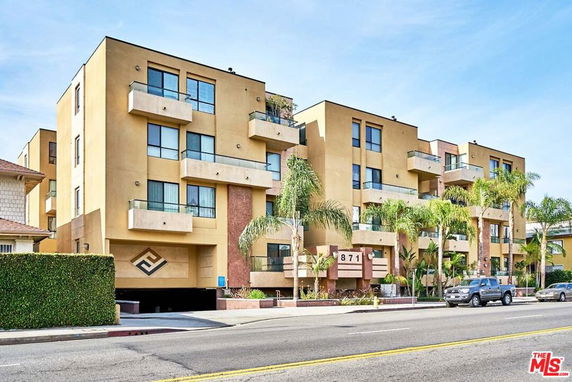 Front view of a multi-story modern apartment building with balconies.