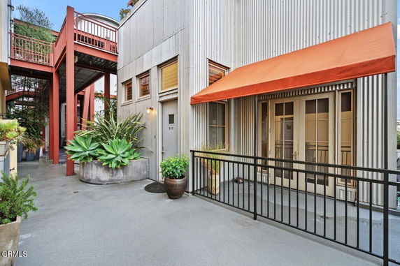 Front view of a building with corrugated metal siding and a bright orange awning.