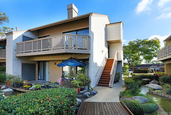 Front view of a two-story house with an external staircase and balcony.