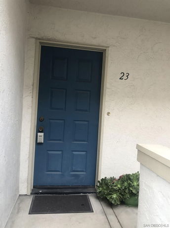 Front view of a house entrance with a blue door and the number 23.