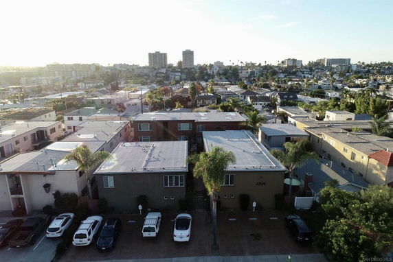 Aerial view of a residential area with multiple houses and cars parked in front.