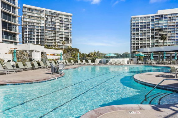 Outdoor swimming pool area surrounded by high-rise apartment buildings.