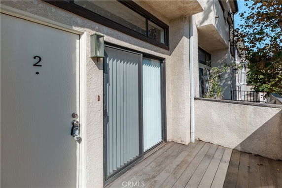 Front view of a building entrance with a door and adjacent glass sliding door.