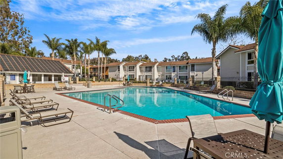 Outdoor swimming pool in front of a residential building complex.