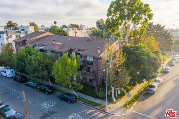 Front view of a multi-story residential building with a sloped roof.