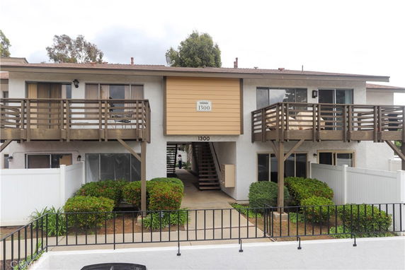 Front view of a two-story building with balconies and an entrance at the center.