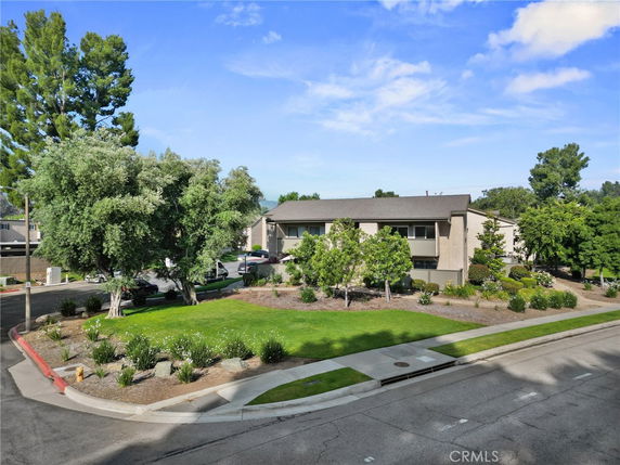 Front view of a two-story building with a landscaped garden.