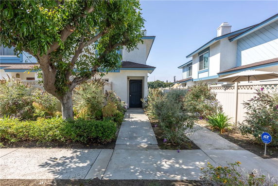 Front view of a two-story house with a garden path leading to the entrance.