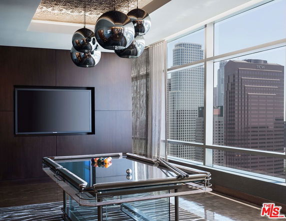 Interior of a recreation area with a pool table and wall-mounted TV.