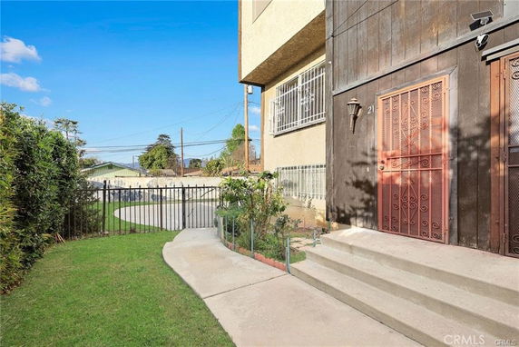 Front view of a building entrance with steps and metal door in an outdoor setting.