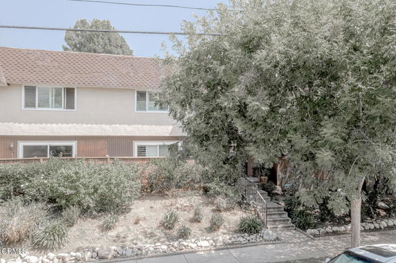 Front view of a two-story house with a sloped roof and large windows.