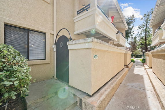 Angled view of a multi-story residential building with balconies and a gated entrance.