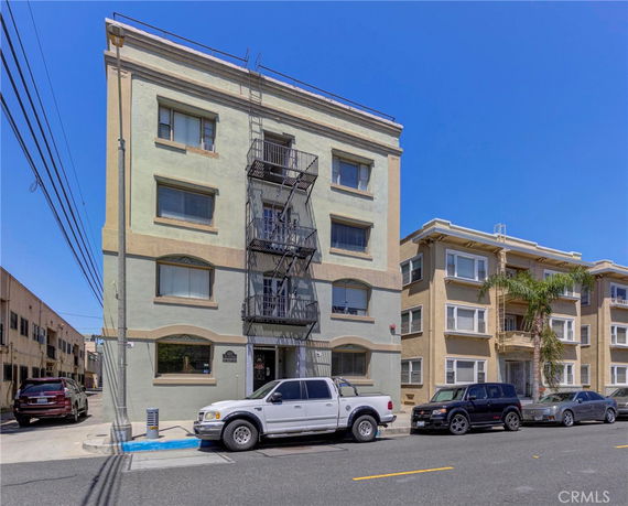 Front view of a multi-story apartment building with a fire escape.